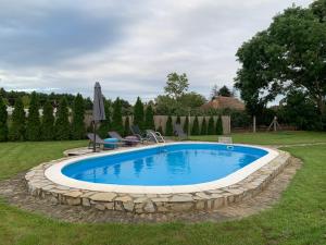 a swimming pool with a stone wall around it at Kuća Miris severa in Šupljak