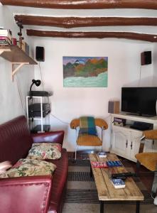ein Wohnzimmer mit einem Sofa und einem Tisch in der Unterkunft Casa Calma en Sierra de Vicort, Zaragoza in Inogés
