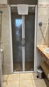 La salle de bains est pourvue d'une douche avec une porte en verre. dans l'établissement Hôtel Lilium Maris, à Tizzano