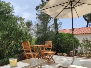 塞辛布拉的住宿－Quinta do Alento，庭院配有桌椅和遮阳伞。
