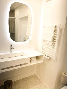 a white bathroom with a sink and a mirror at Im Ramsen - Familie Baier in St. Wolfgang