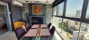 a dining room with a table and chairs and windows at Luxury open-space apartments by the sea in Ashdod