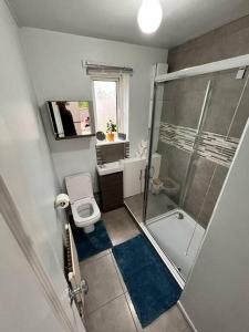 a small bathroom with a shower and a toilet at Beautiful House in Bournemouth in Longham