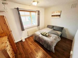 a bedroom with a bed and a window at Beautiful House in Bournemouth in Longham