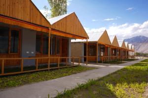 uma fila de casas com montanhas ao fundo em THE RIVERSIDE RESORT Hunder em Leh