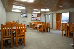 een eetkamer met houten tafels en stoelen bij THE RIVERSIDE RESORT Hunder in Leh