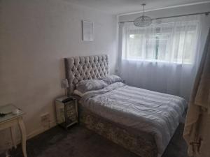 Immaculate 1-Bed Apartment in Woodford Green في وودفورد غرين: غرفة نوم صغيرة مع سرير مع نافذة