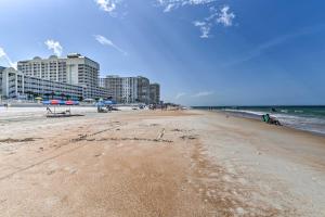 plaży z niektórymi budynkami, oceanem i krzesłami w obiekcie Dreamy Daytona Studio with Beach Access! w mieście Daytona Beach