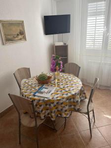 a dining room table with a yellow and white table cloth at Apartments Furlan in Portorož +27 photos