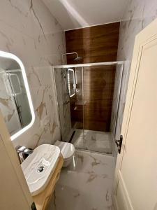 y baño blanco con lavabo y ducha. en Luxury city rooms, en Ogulin