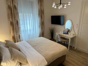 a bedroom with a bed and a desk and a mirror at Luxury city rooms in Ogulin