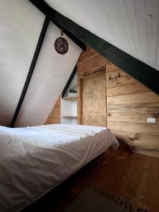 a bedroom with a white bed in a attic at Habitación cálida y acogedora a pasos del mar in Buchupureo
