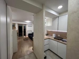 una cucina con armadi bianchi e un soggiorno di Apartman Sara a Zenica