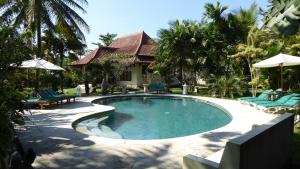 a swimming pool in front of a house at Rumah Kita Villa/hotel in Kalibaru