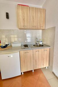 a kitchen with wooden cabinets and a sink at Montenegrina Apartment in Budva