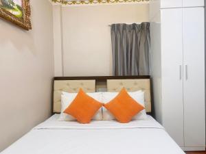 two orange pillows sit on a bed in a bedroom at CROWNE BUI VIEN Hotel in Ho Chi Minh City
