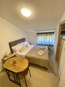 a bedroom with a large bed and a table at Theros in Bibinje