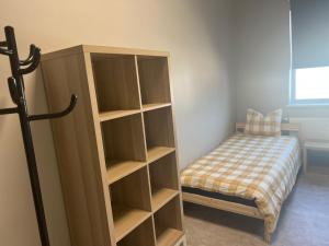 a bedroom with a book shelf next to a bed at Worker hotel ALEJPARKS in Valmiera
