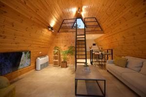 uma sala de estar com uma escada numa parede de madeira em Kompleksi Turistik DEA em Shkodër