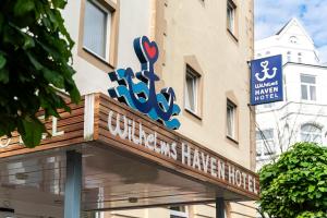 Wilhelms HAVEN HOTEL في فيلهلمسهافن: لافته للفندق امام مبنى