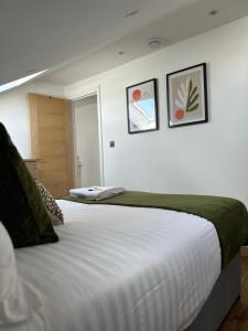 a bedroom with two beds and two pictures on the wall at Cornwall - The Duke and Duchess in London