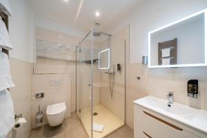 La salle de bains est pourvue d'une douche, de toilettes et d'un lavabo. dans l'établissement Wilhelms HAVEN HOTEL, à Wilhelmshaven