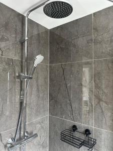 a shower with a shower head in a bathroom at Cornwall - The Duke and Duchess in London