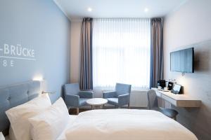 um quarto de hotel com uma cama, uma secretária e cadeiras em Wilhelms HAVEN HOTEL em Wilhelmshaven