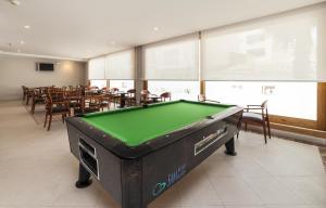 a pool table in a room with tables and chairs at Mix Colombo in S'Illot