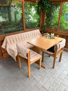 a wooden table and bench on a patio with a table and chairs at Ferienwohnung MaLi in Arrach