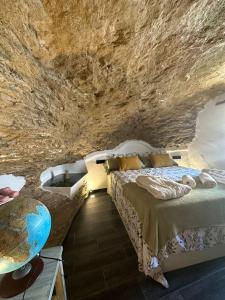 Zimmer mit einem Bett und einer Badewanne in einer Höhle in der Unterkunft Tajito Romano in Setenil de las Bodegas
