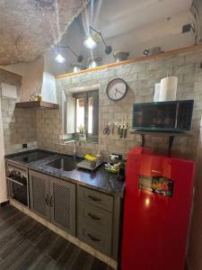 eine Küche mit einem roten Kühlschrank und einer Mikrowelle in der Unterkunft Tajito Romano in Setenil de las Bodegas