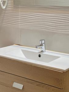 a white sink in a bathroom with a mirror at Apartamentos Lidar in Bilbao