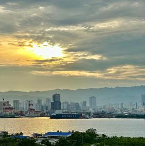 Seaview Sunset Accommodation في مدينة سيبو: أفق المدينة مع غروب الشمس على المياه