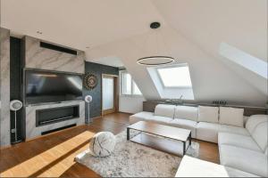 a living room with a white couch and a tv at Luxury rooftop appartment with fantastic views in Prague