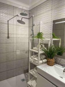 a bathroom with a shower with a sink and a mirror at Elegance to close from Lisbon! in Montijo