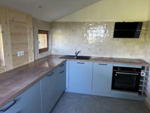 a kitchen with white cabinets and a sink at Chalet la parenthèse in Le Tholy +14 photos
