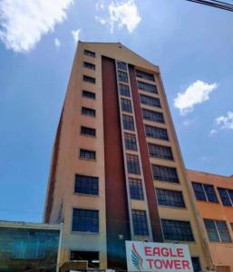 um edifício alto com um sinal em frente em Nairobi Affordable studio apartments hosted by Lilian em Nairobi