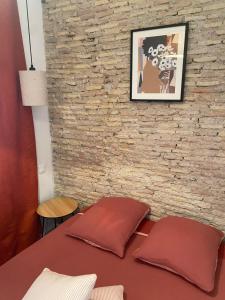 a table with two pillows in front of a brick wall at Soo Major Magnifique T2 au Panier in Marseille