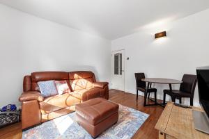 sala de estar con sofá de cuero y mesa en Comfortable 1BR flat in Canary Wharf en Londres