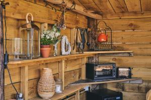 una cocina con paredes de madera y estanterías con microondas en Curious Calf en Leominster