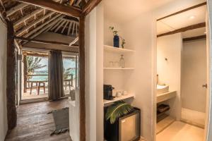 um quarto com televisão e vista para o oceano em Niken Beachfront Tulum Hotel em Tulum