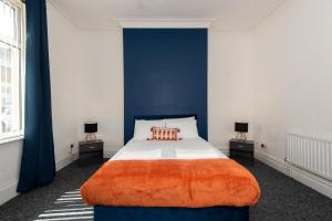 a bedroom with a large bed with blue walls at Rose Street in Monkwearmouth