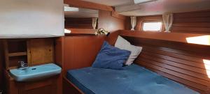 a small room with a sink and a blue bed at Your Sailing House Sardinia in San Teodoro
