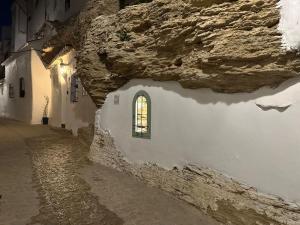 un edificio de piedra con una ventana en una calle en Tajito Romano, en Setenil