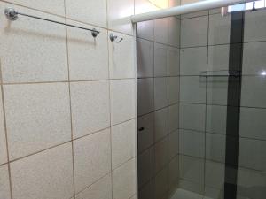 a shower with a glass door in a bathroom at Madeira Lofts - Suite 01 in Juína