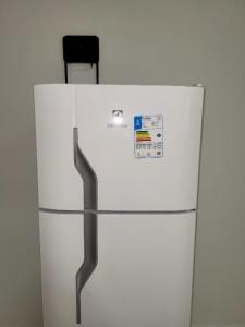 frigorifero bianco in una stanza con parete bianca di Madeira Lofts - Suite 01 a Juína