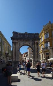a group of people walking in front of an arch at MC Centar Apartman in Pula