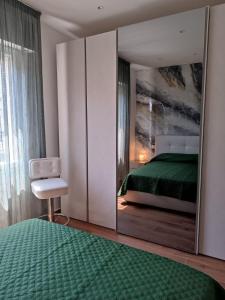 a bedroom with a green bed and a mirror at 0541 Guest House Rimini in Rimini