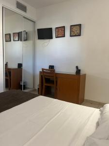 - une chambre avec un lit blanc et un bureau dans l'établissement Hôtel Lilium Maris, à Tizzano